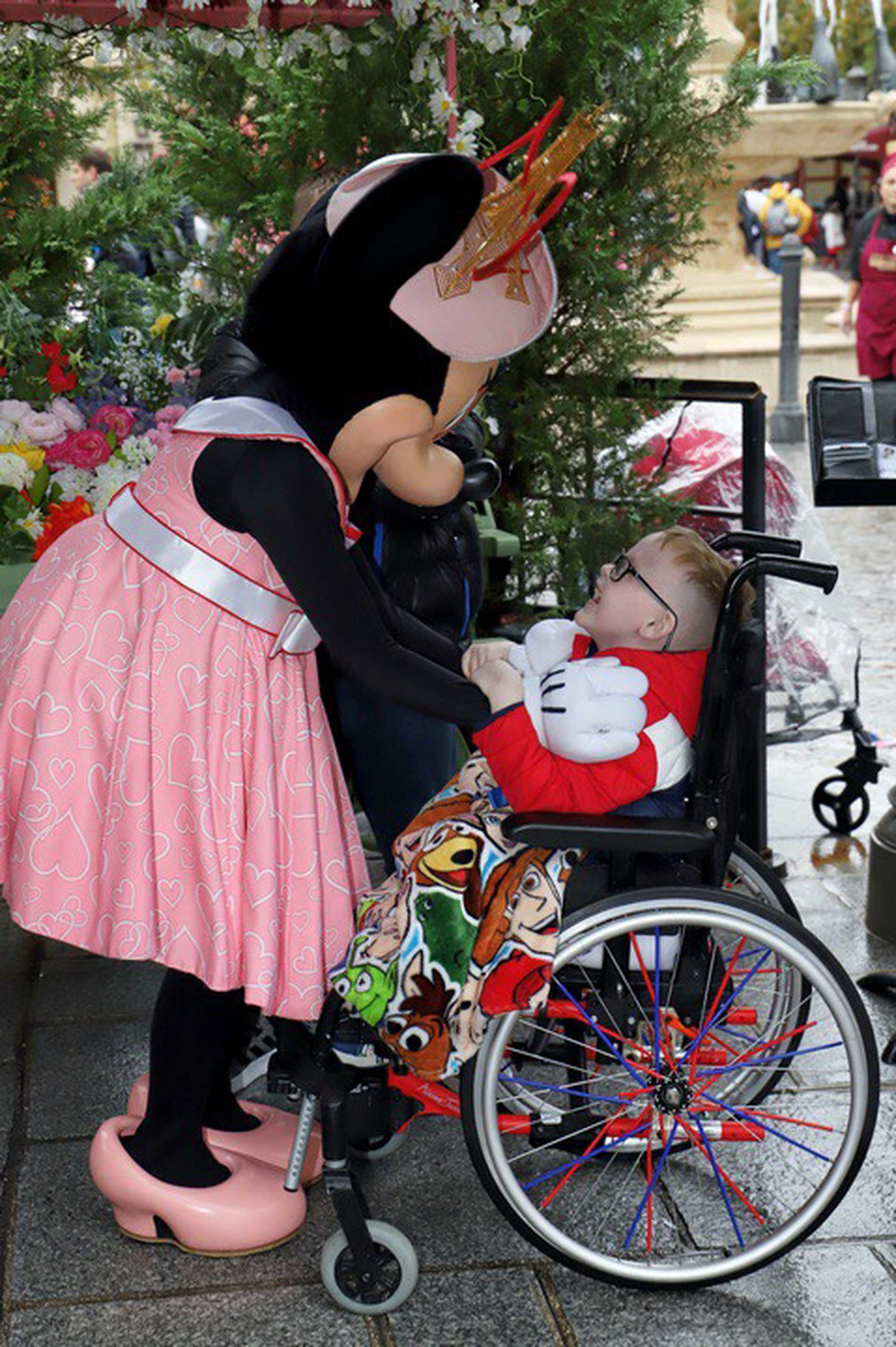 Patrick sitting in his wheelchair with a big smile as he meets Minnie Mouse.