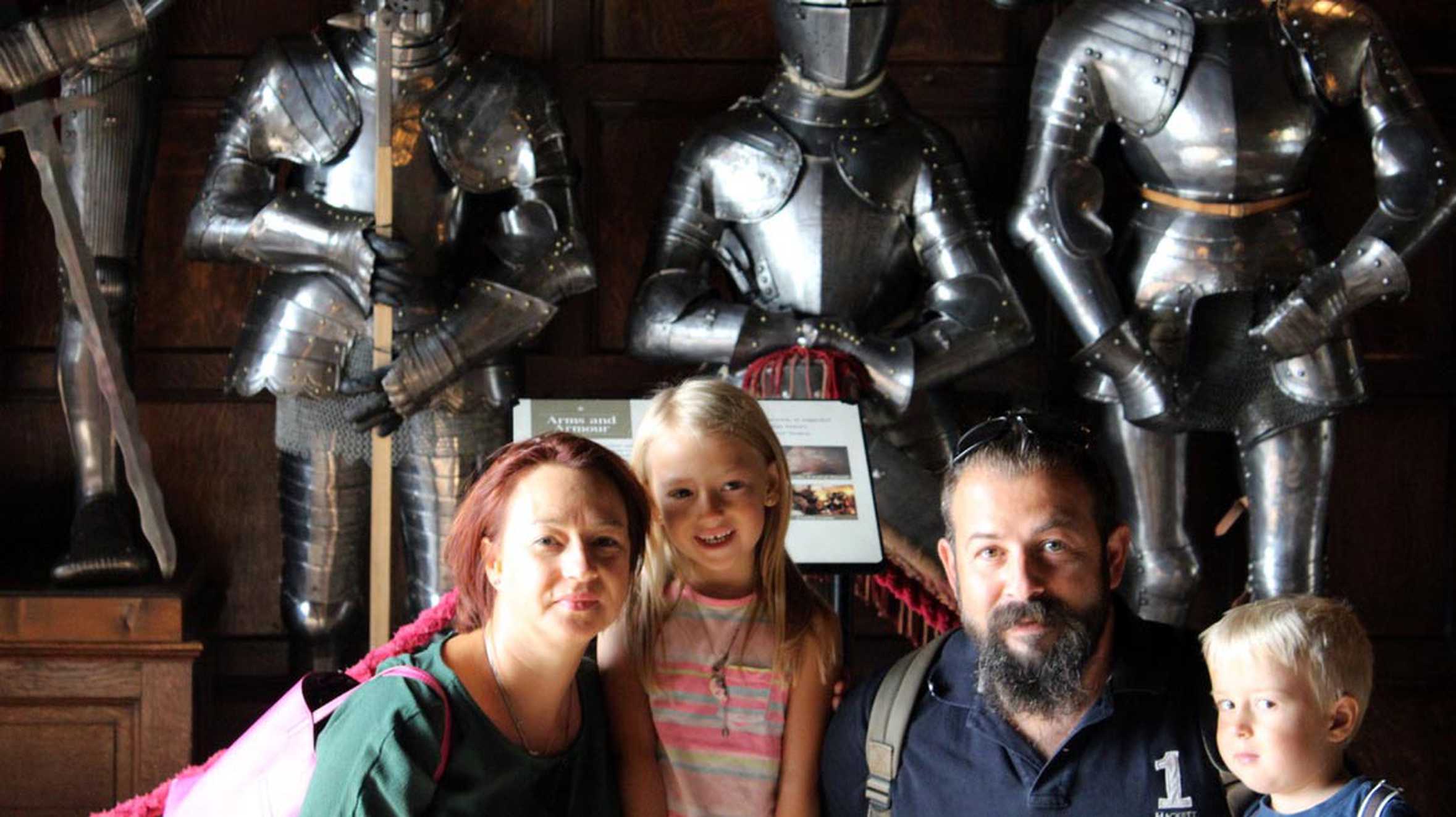 Hunor and his family posing in front of several suits of armour.