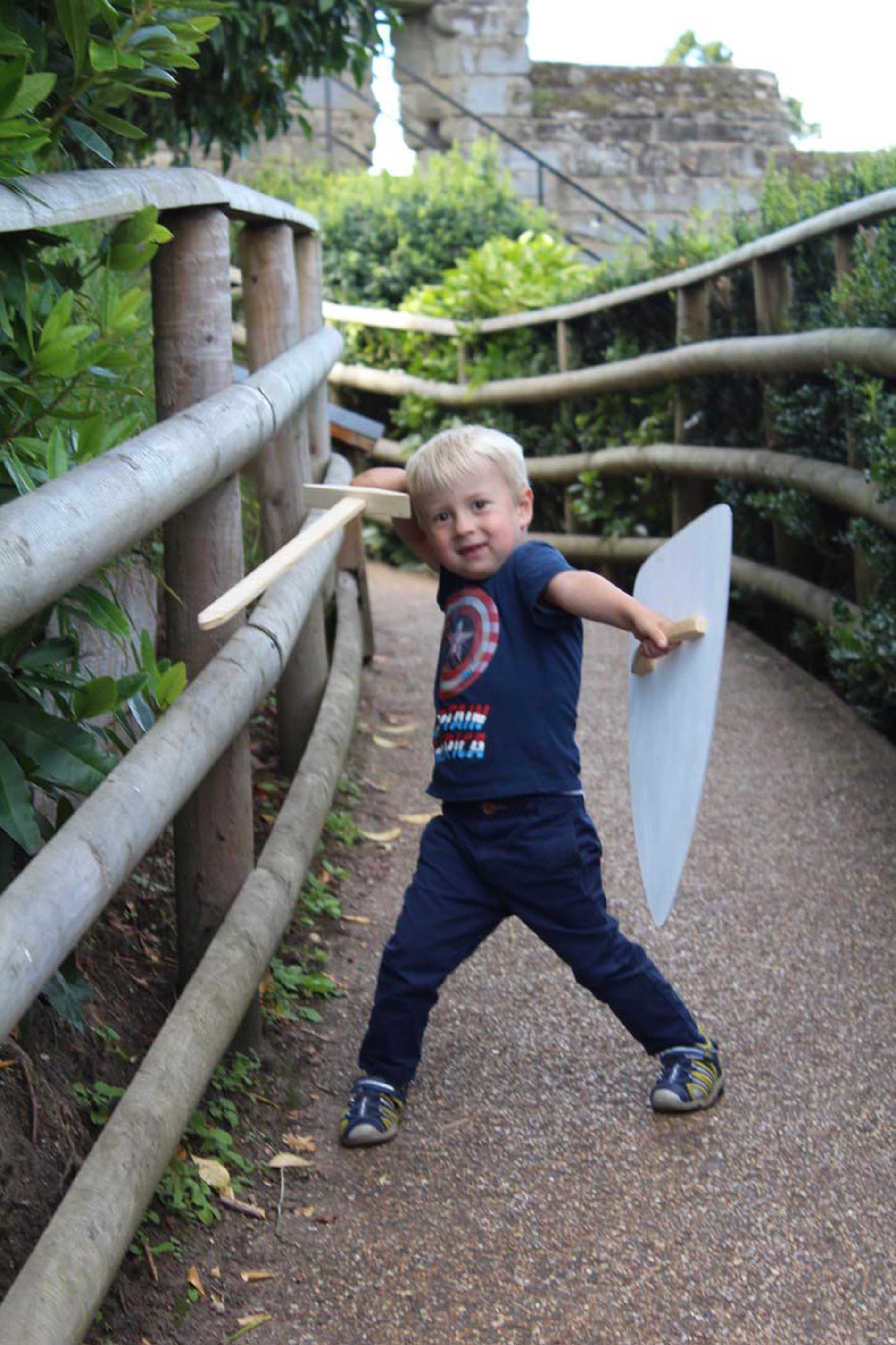 Hunor wielding his sword and shield in front of Warwick Castle.