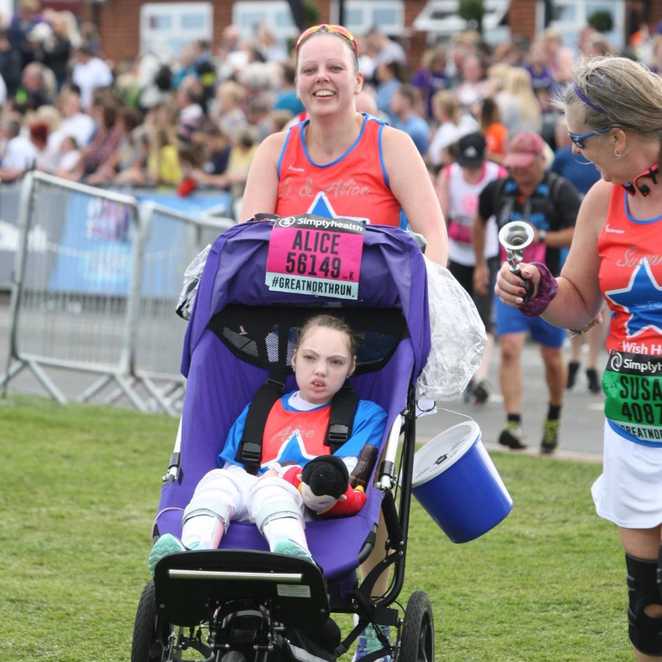 Alice and Jo, wearing their Make-A-Wish running tops and collecting money while running.