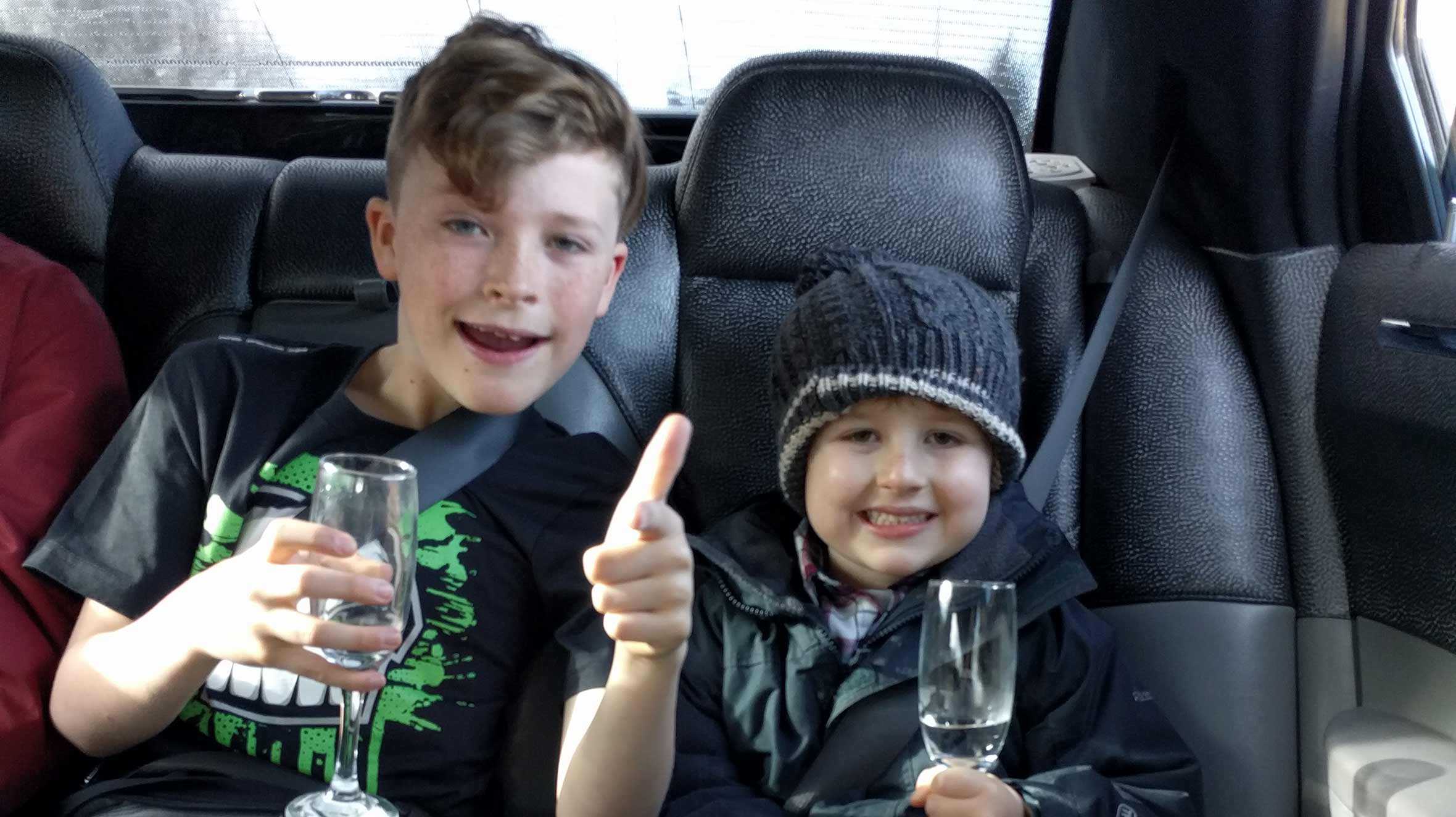 Joseph and his brother drinking fake Champagne in the limo