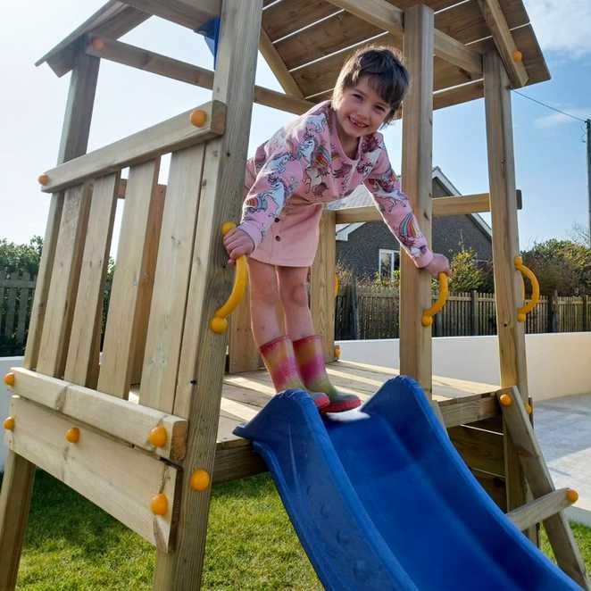 Indeg playing on her new garden play set in the sunshine.