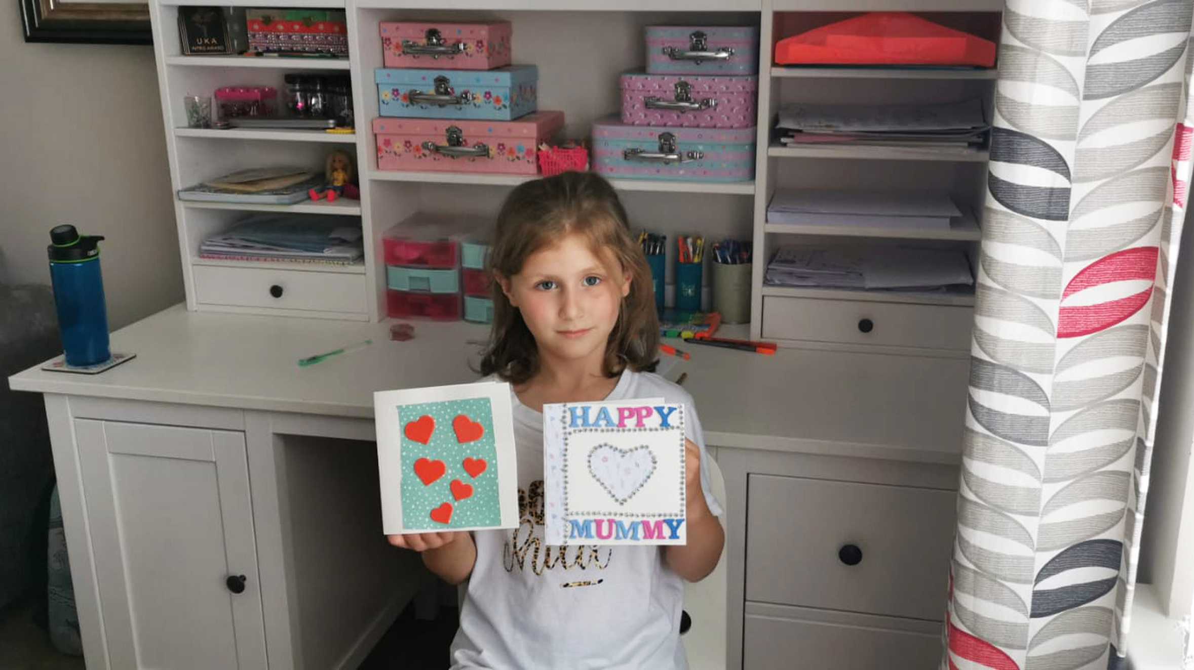 Wish child, Bethany holding up some greetings cards she made.