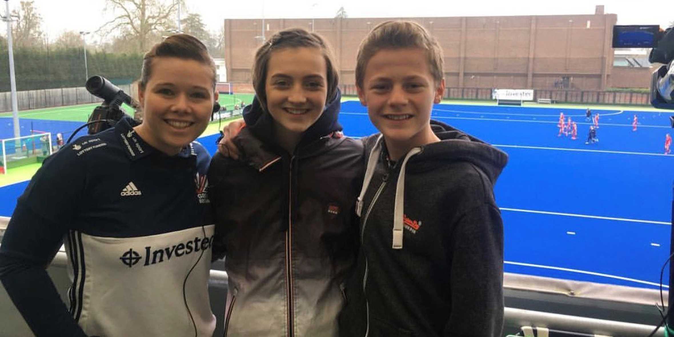 Lucy at standing with her brother and a GM hockey team member at the training ground