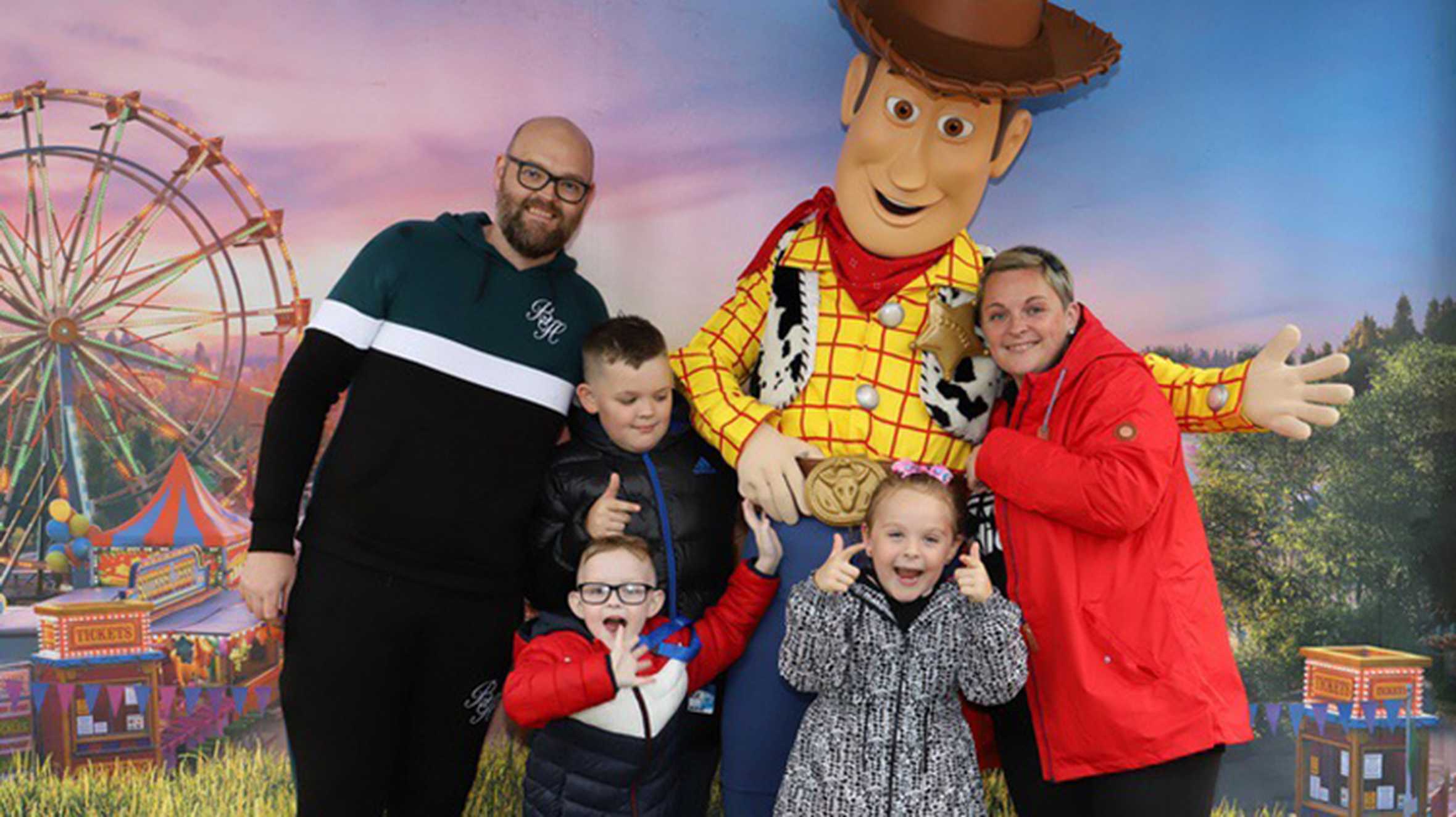 Patrick and his family posing with Woody from Toy Story.