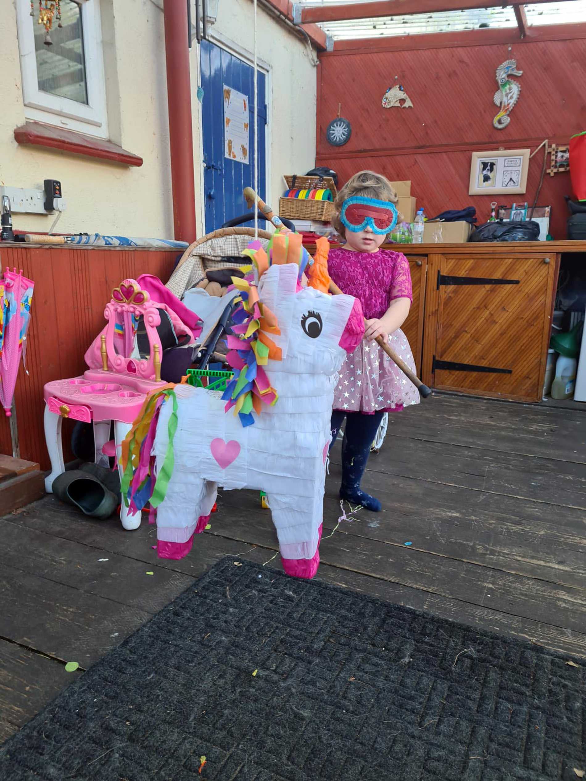 Leah in the back yard, about to take a swing at her Pinata.