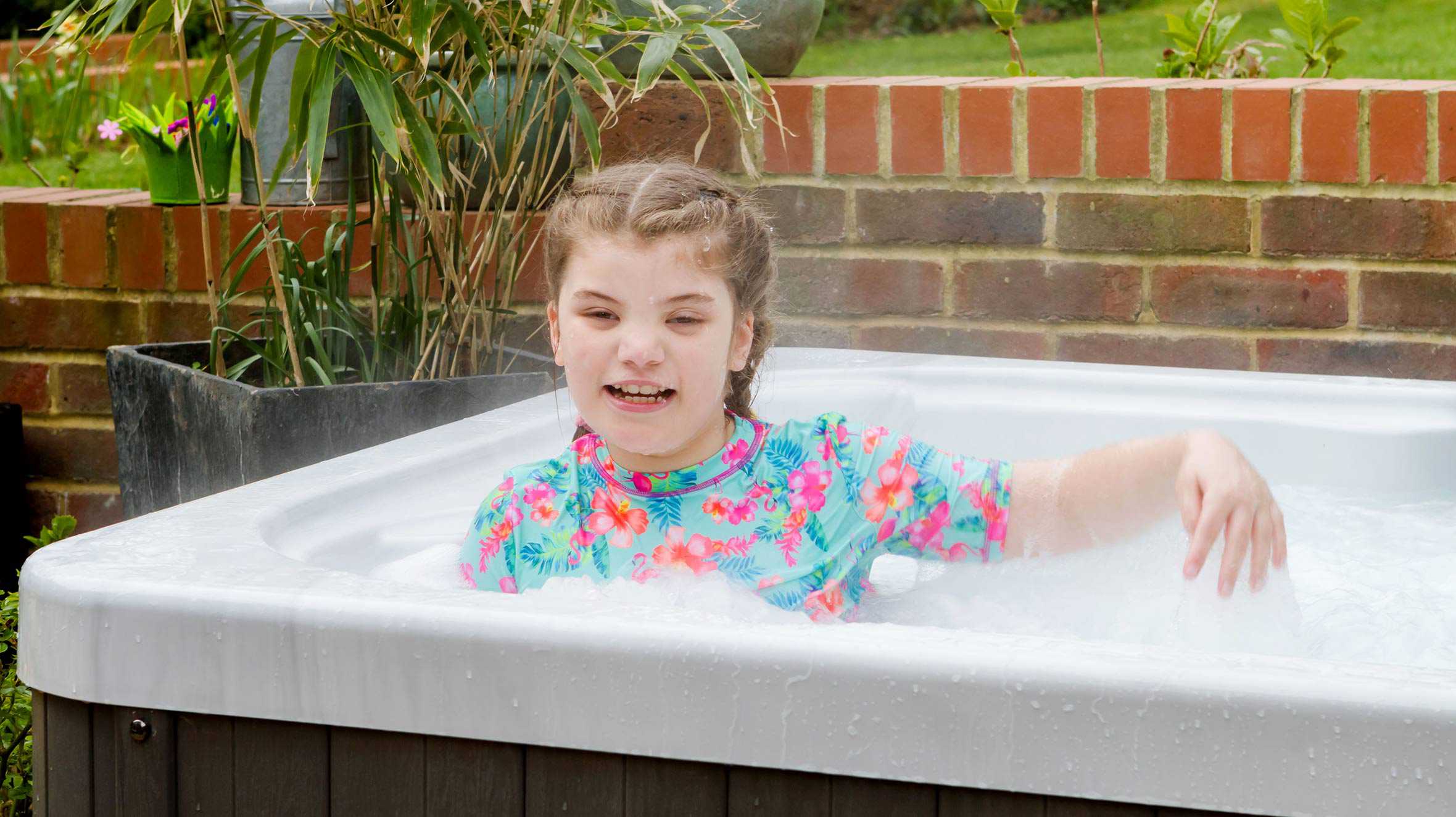 Wish child, Gracie, smiling in her new hot tub.