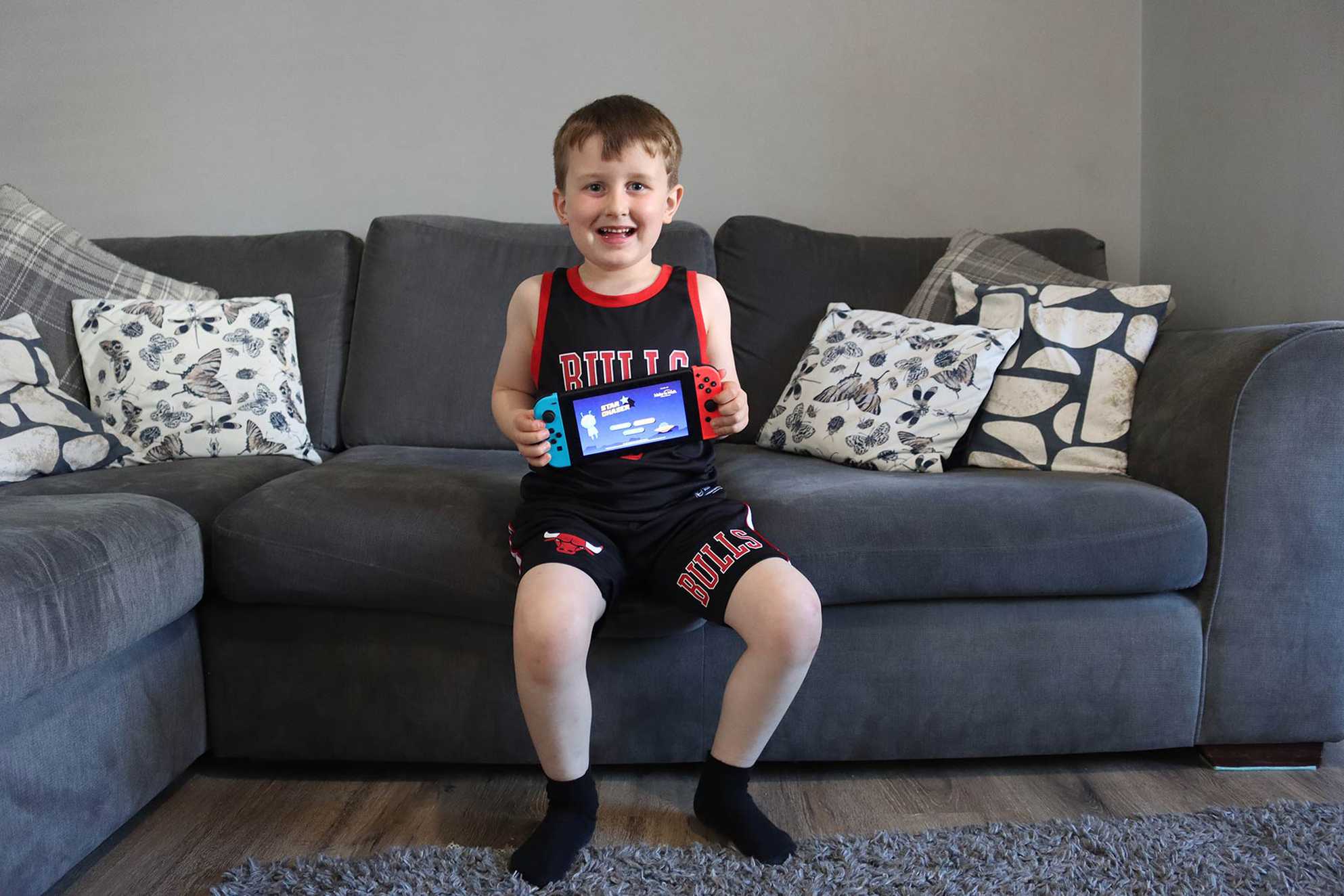 Oliver, proudly holding up his new Nintendo Switch.