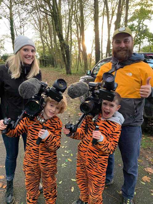Stanley and his friend, Morgan standing with the film crew in tiger onesies.