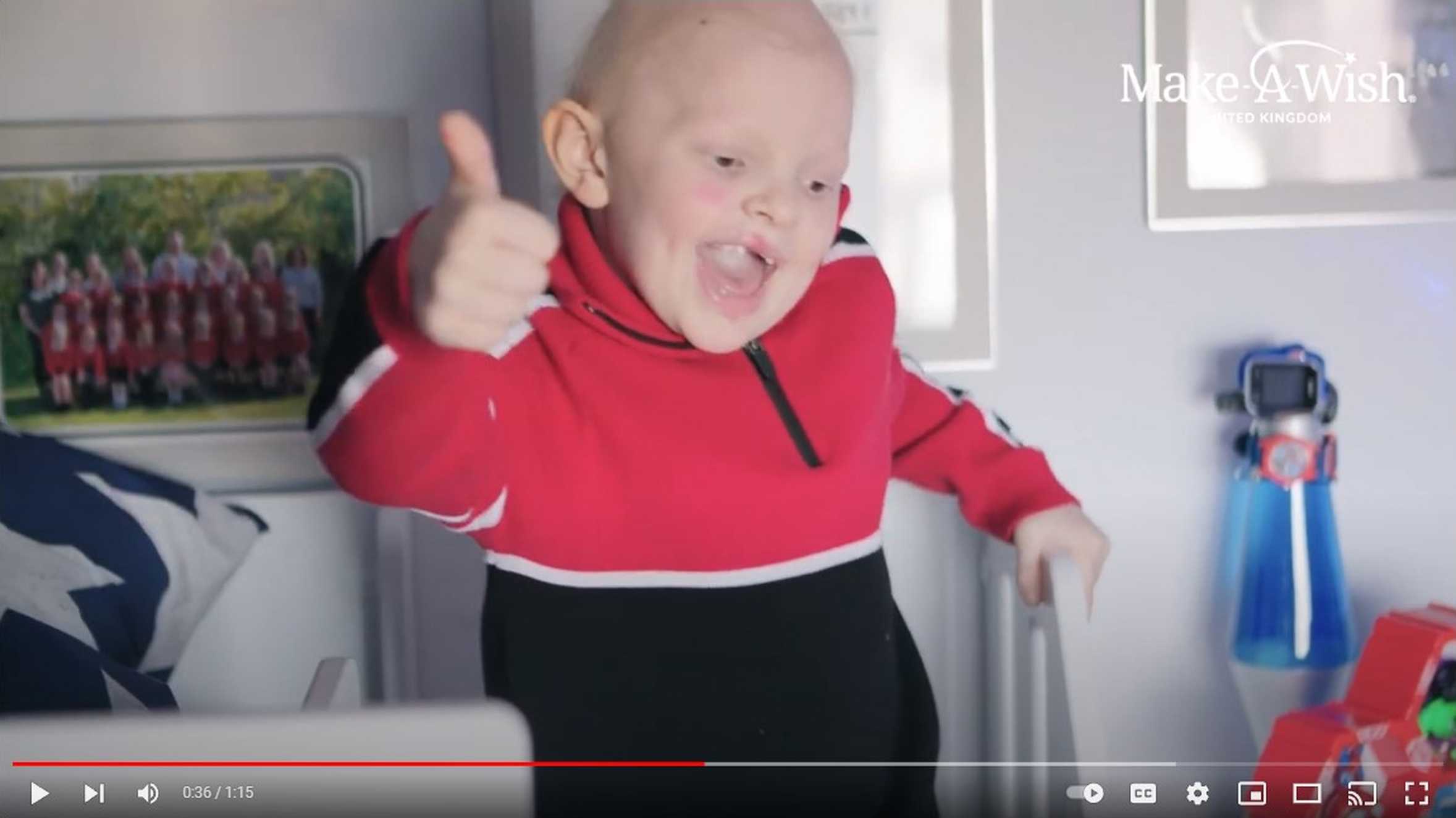 Aaron giving a thumbs up while sitting on his new cabin bed.