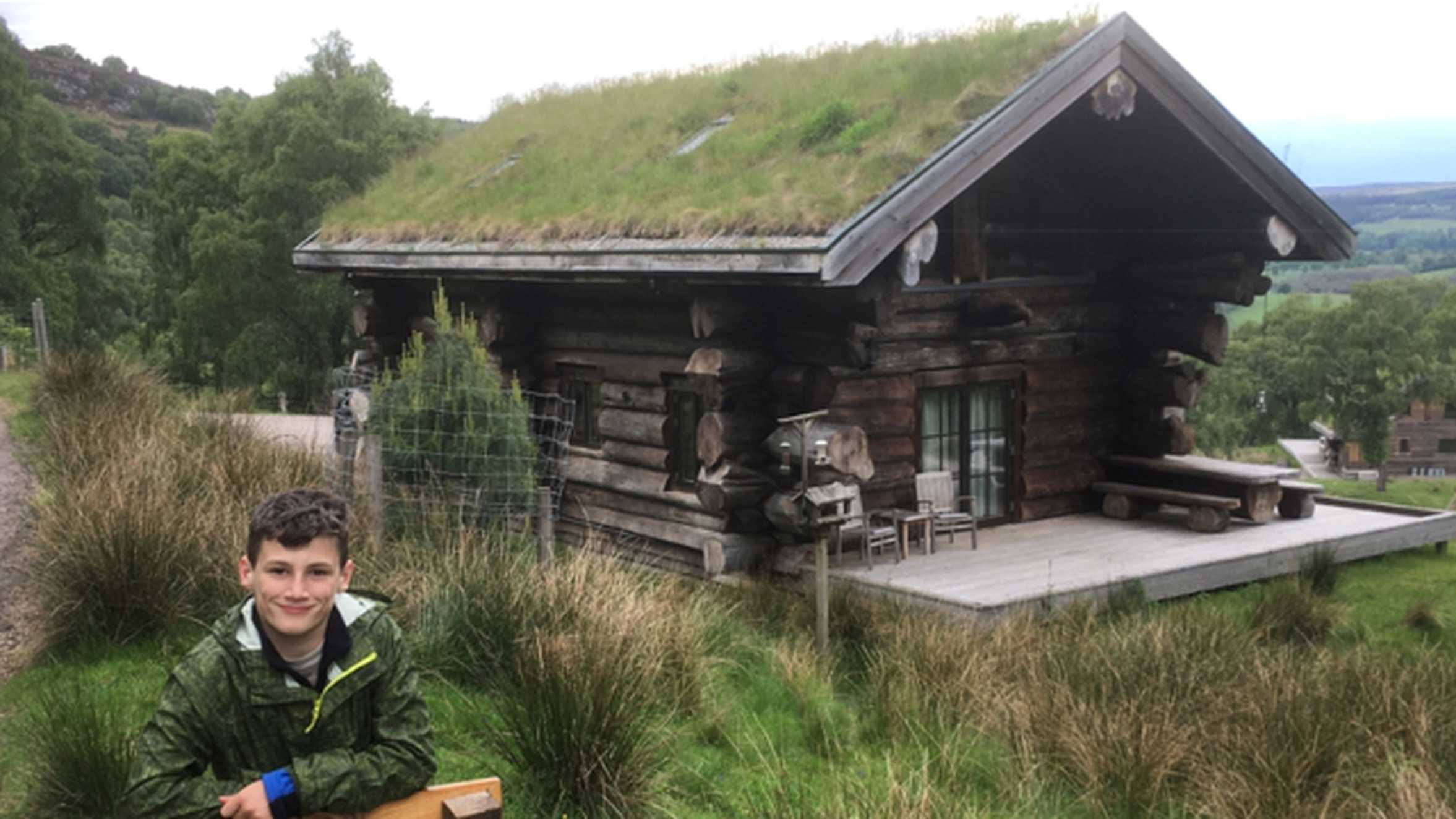 Wish child Brandon outside his cabinon his wish in the Scottish Highlands