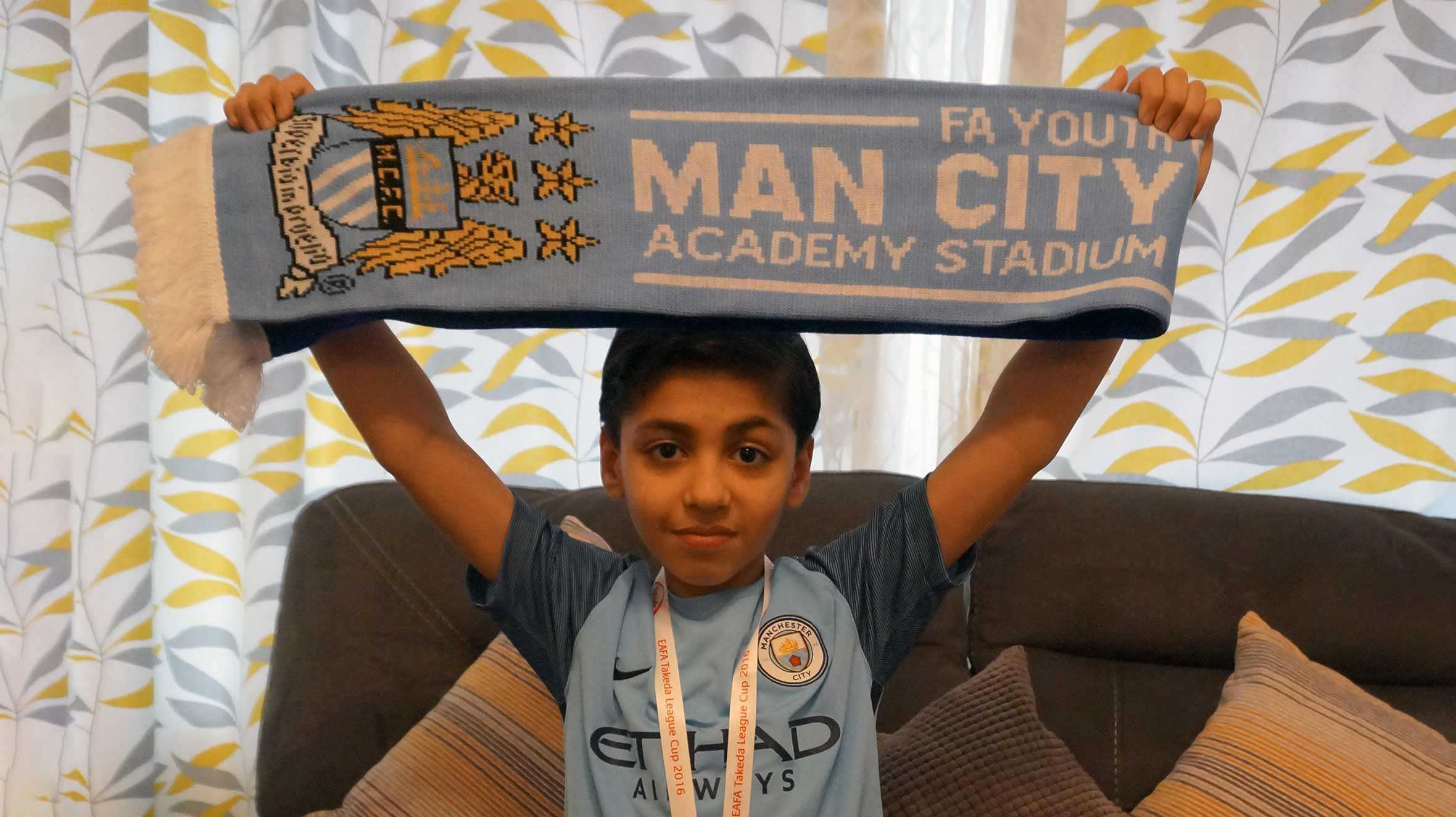 Idris holding up his Manchester City FC scarf