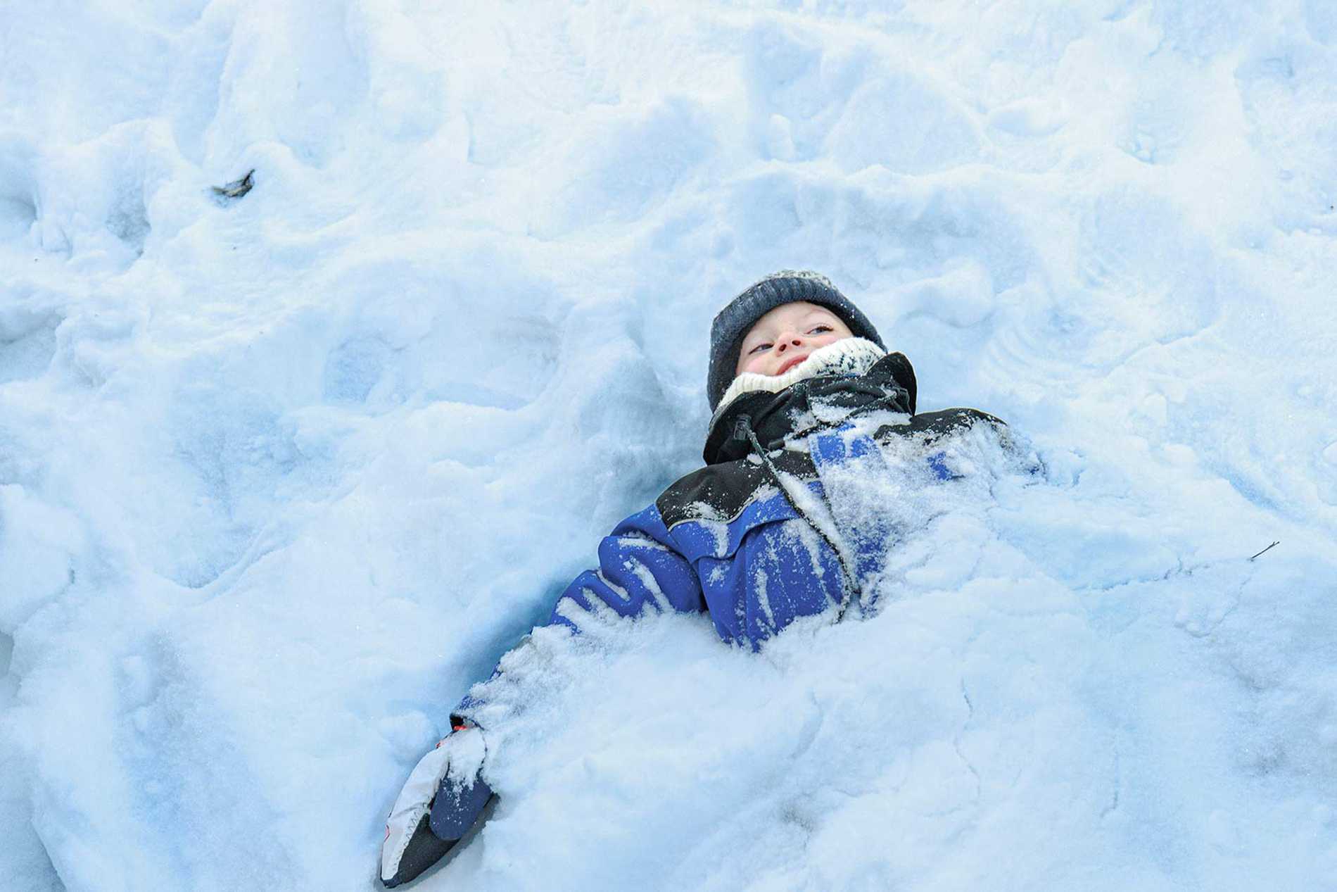 James almost completely buried in snow, with just his head and shoulders poking out.