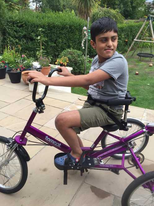 Aaryan trying out his new trike in his garden.