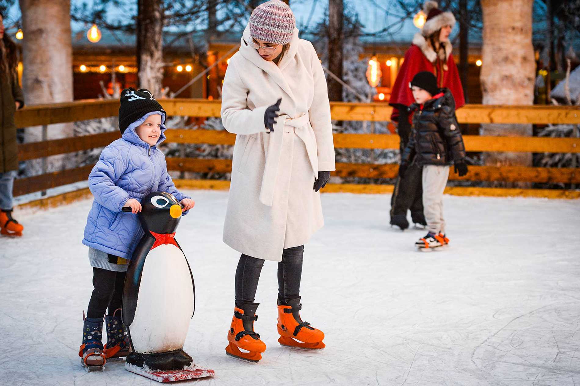 Julia holding onto a penguin stabiliser while she ice skates with mum.