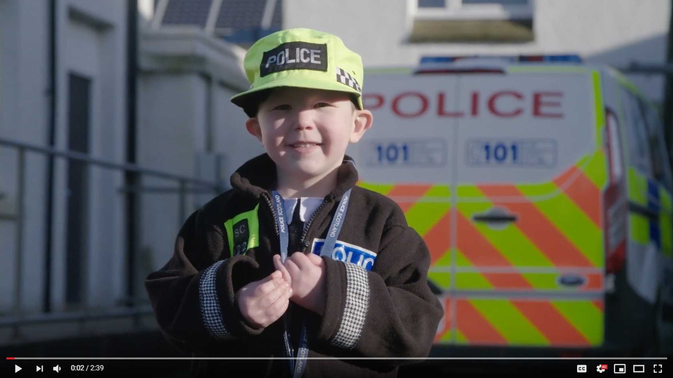 Wish child, Scott in his police uniform with a police van in background.