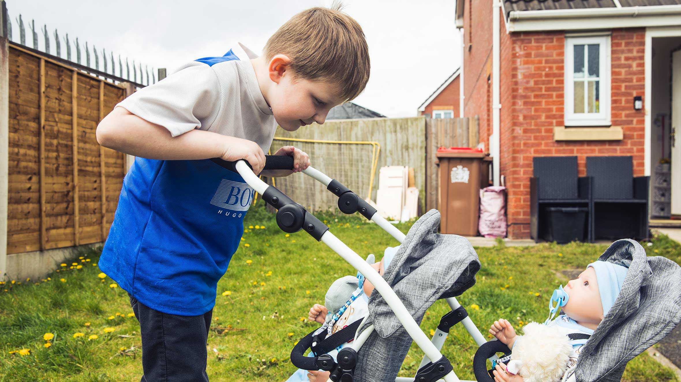 Andrew looking down at his two 'babies' in their special double pram.