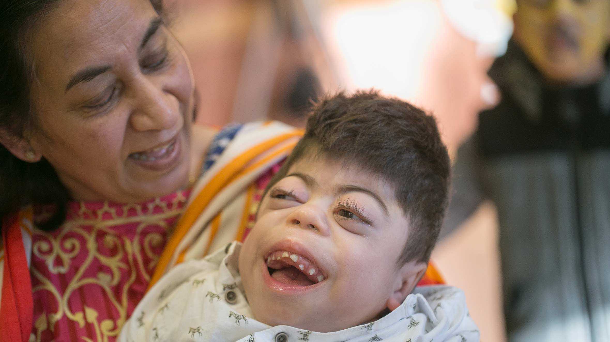 Adnan in his grandmother's arms, with a big smile on his face