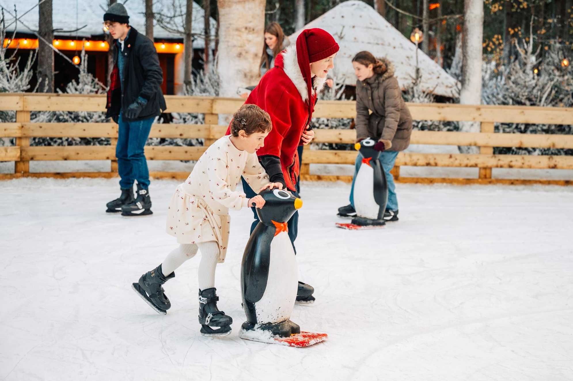 Imogen-Leigh skates on an outdoor ice rink holding a penguin support