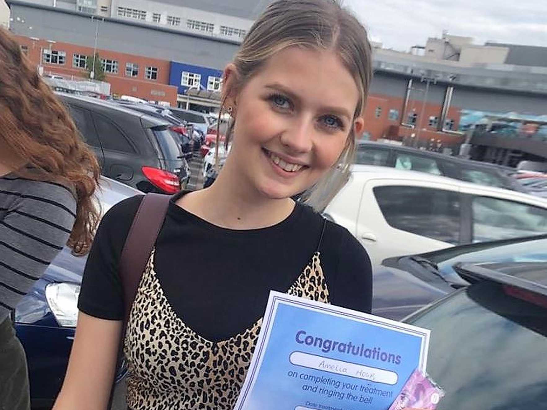 Amelia with her certificate after ringing her end of treatment bell.