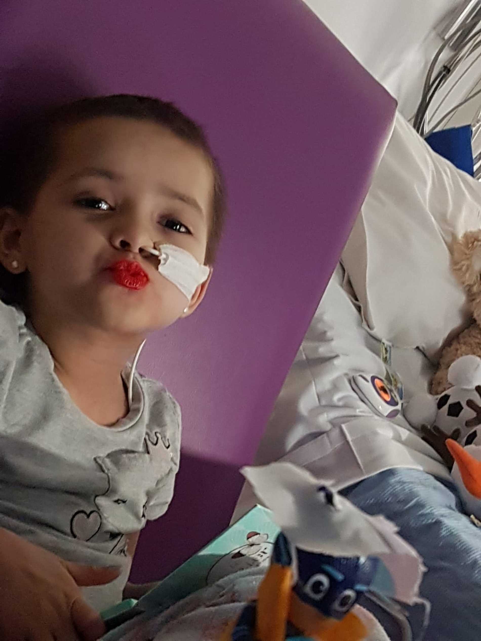 Kelsey in her hospital bed, wearing bright red lipstick