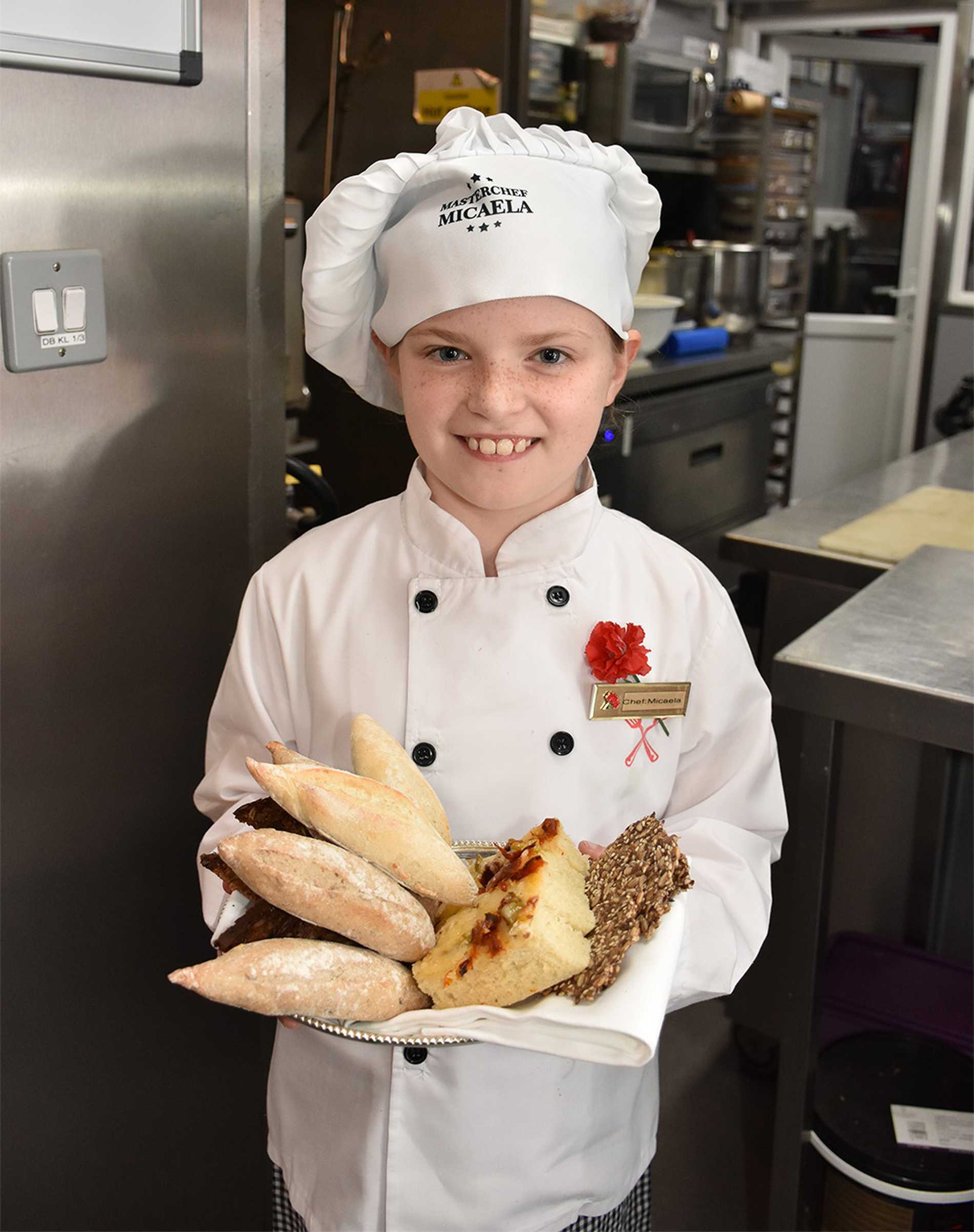 Micaela holding a basket of freshly baked bread.