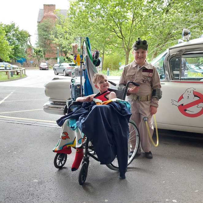 George standing by Ecto 1 with Leeds Hospital patient, Oscar.