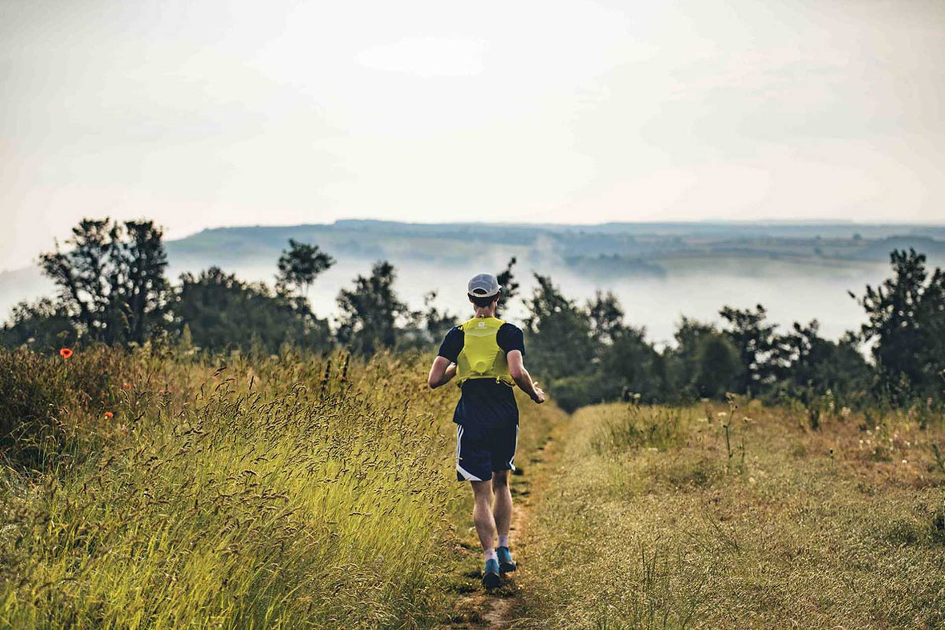 A rear view of a lone runner with the stunning UK countryside spreading out in front of them.