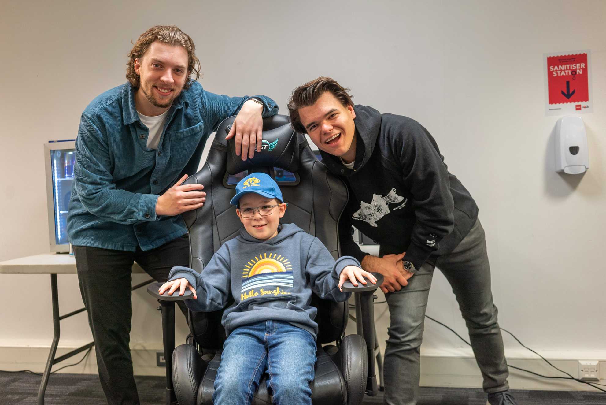 Ewan sits in a gaming chair with Slogo and Jelly stood next to him