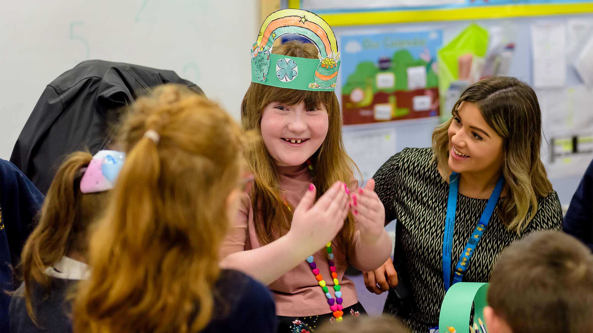 Leah sitting down with another teacher and her students