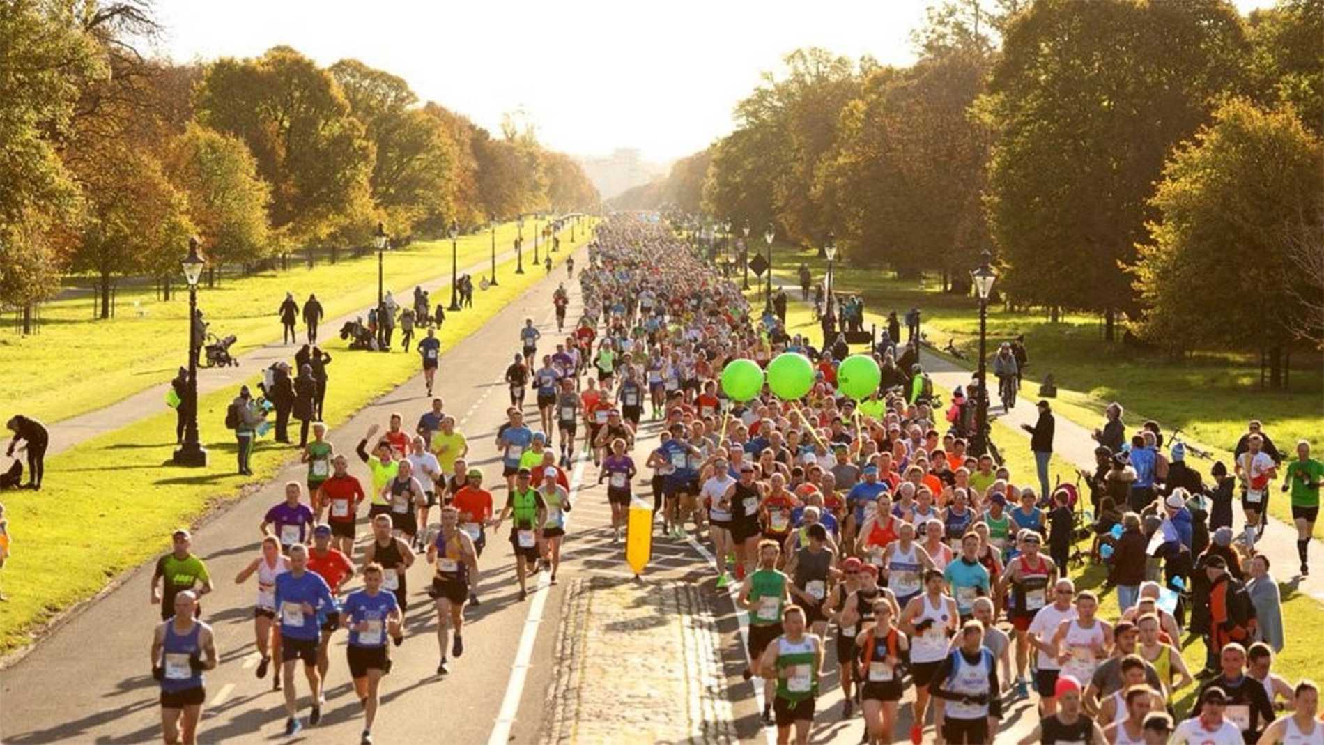 An elevated view of Dublin Marathon runners making their way through one of Dublin's parks on a beautiful sunny day.