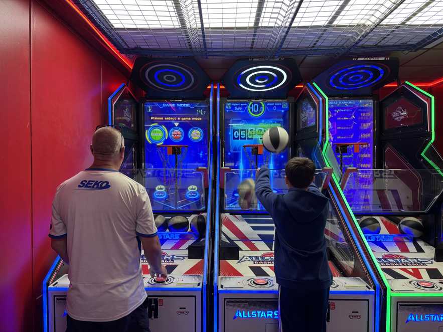 Ramsay and his dad play on the colourful basketball machines at the seaside arcades.