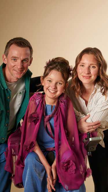 Elspeth poses with her mum and dad with her new outfit
