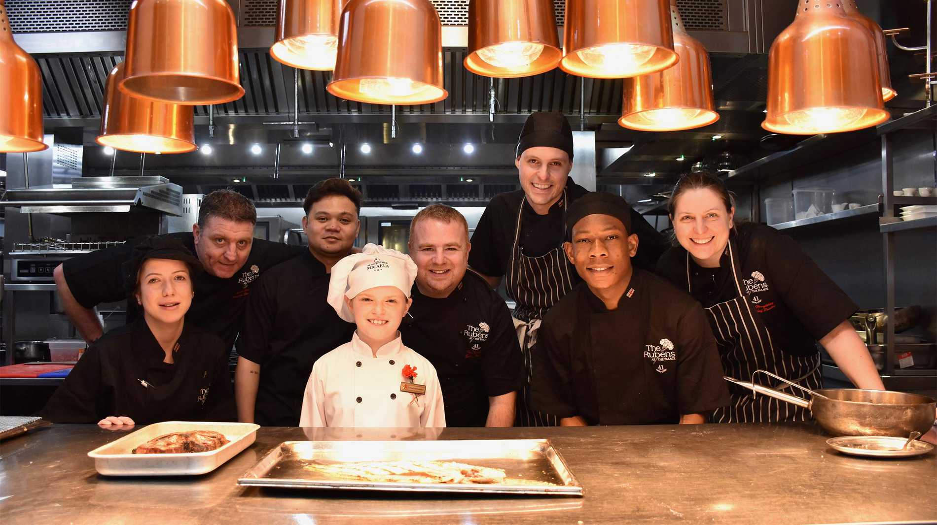 A group photo of Micaela and the Reubens Hotel's catering staff in the hotel kitchen.