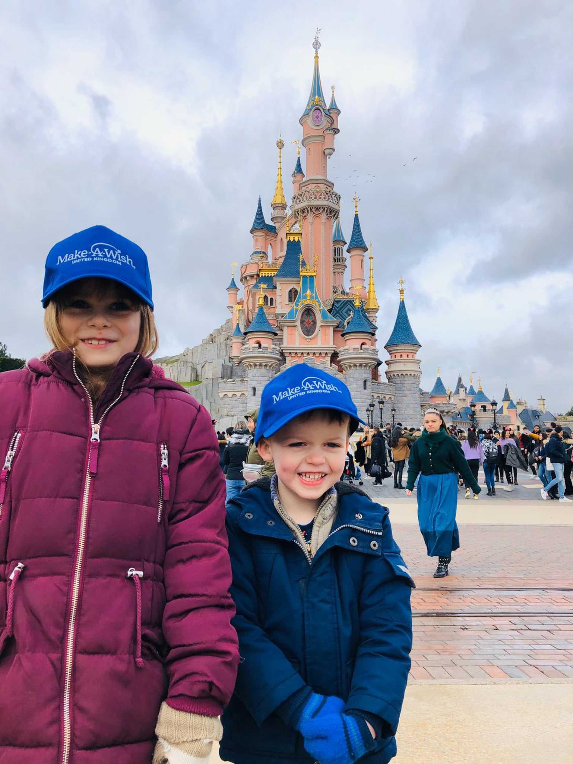 Ezekiel and his sister in front of the magical castle at Disneyland Paris.