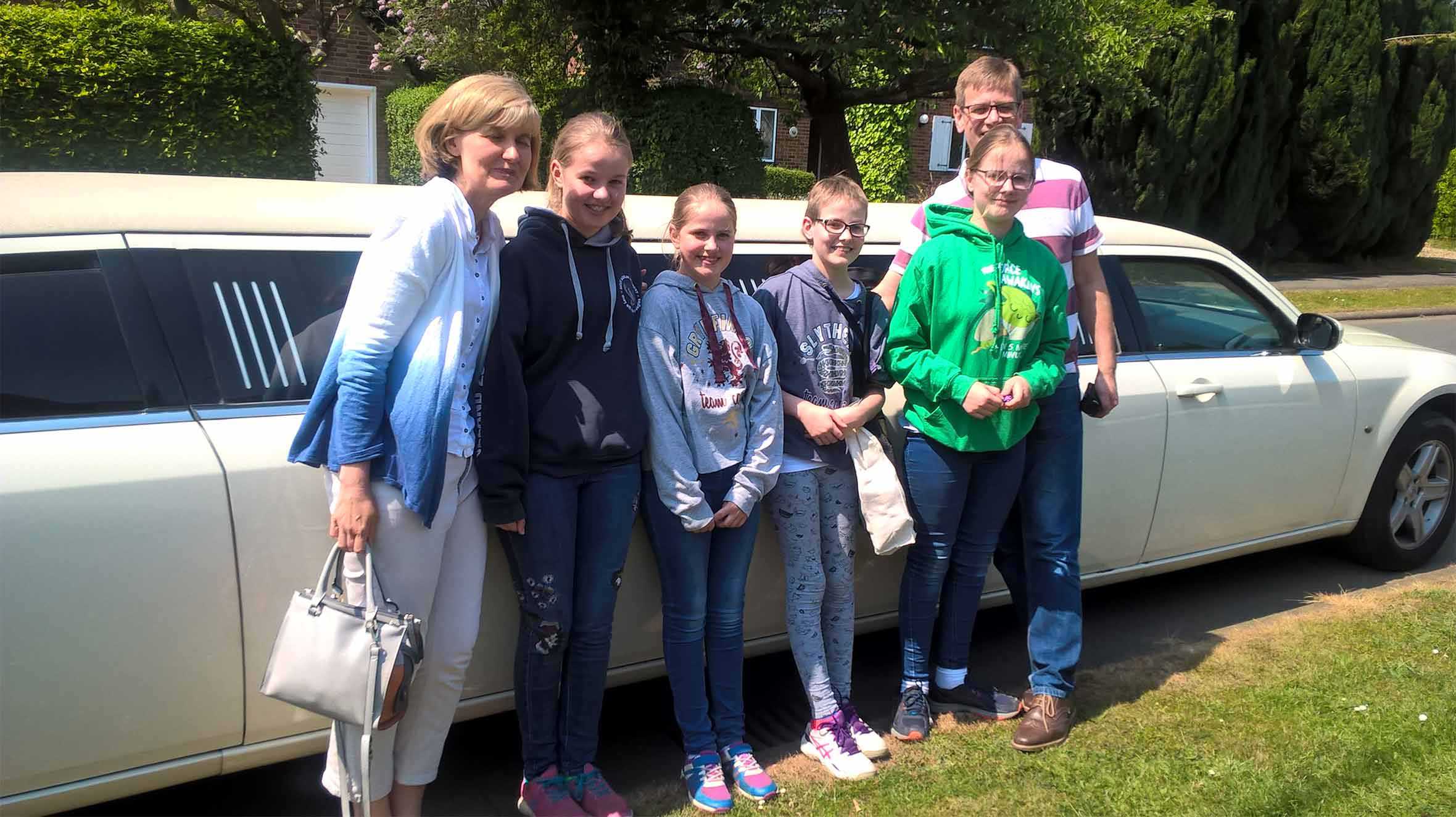 Wish child, Maddie and her family standing in front of a white limo.