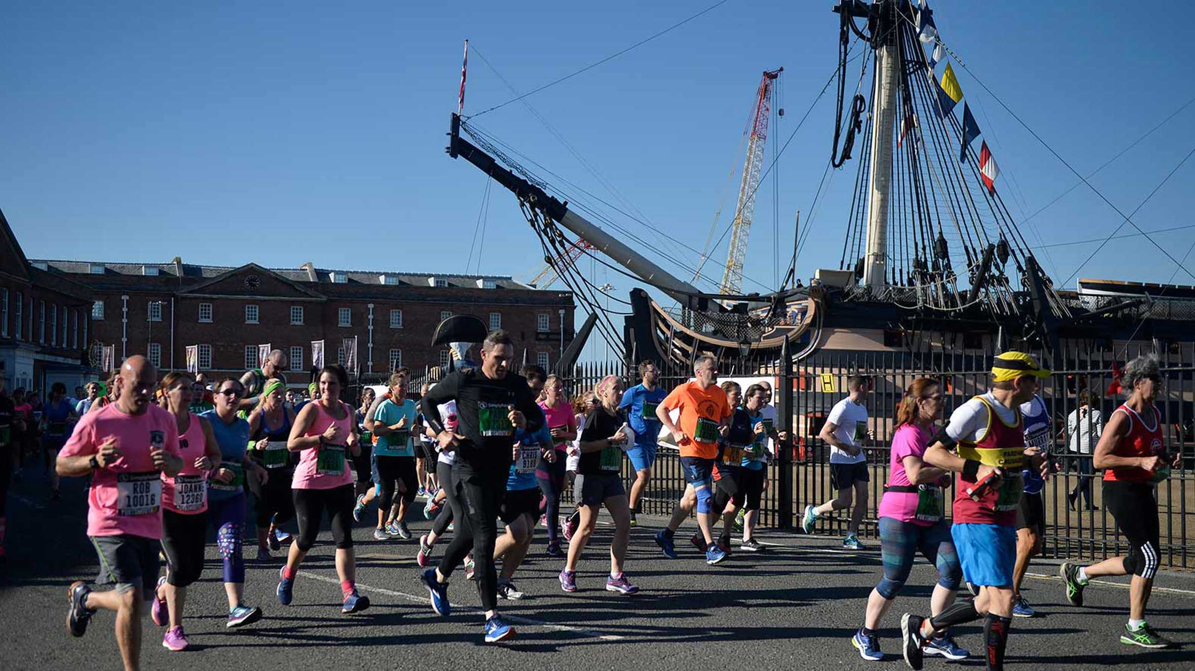 Runners passing a historic ship during the Great South Run.