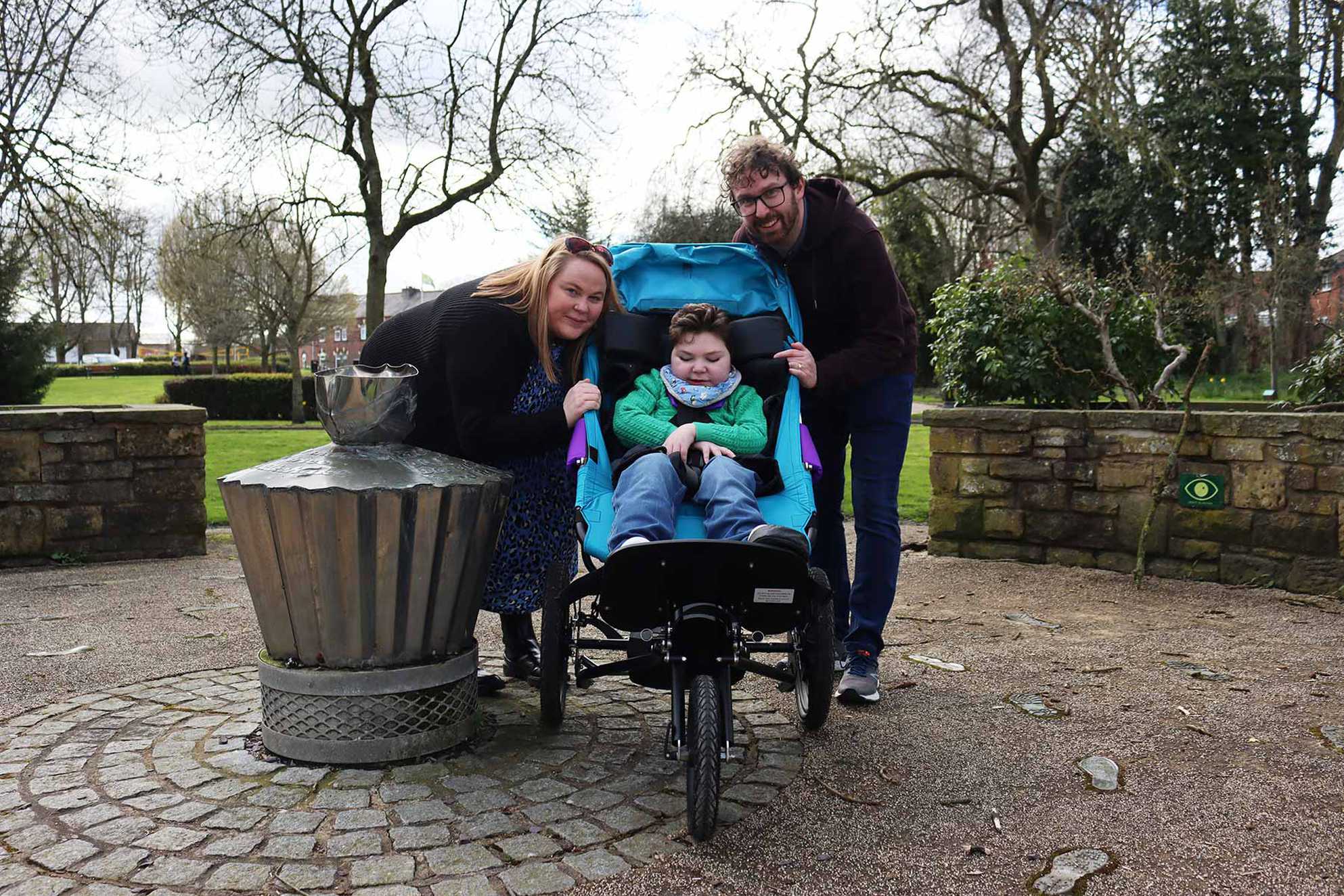 Zachariah with his mum and dad while visiting his local park in his new buggy.