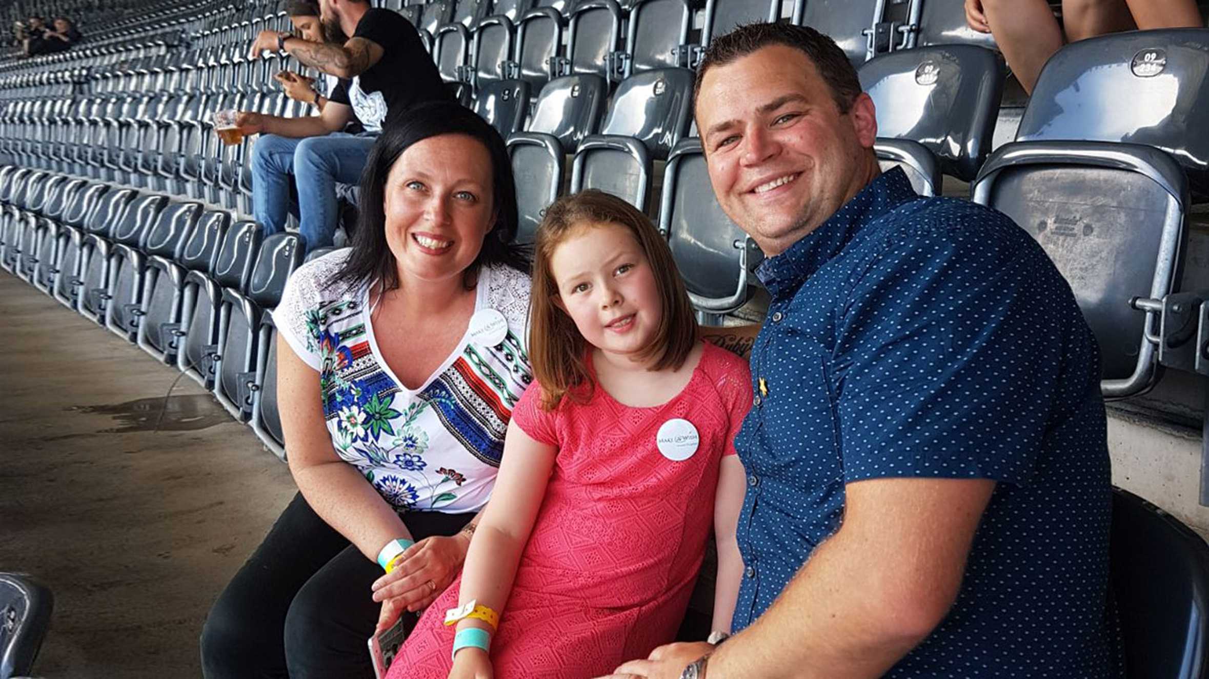 Ruby and her parents in the arena, waiting for the concert to start.