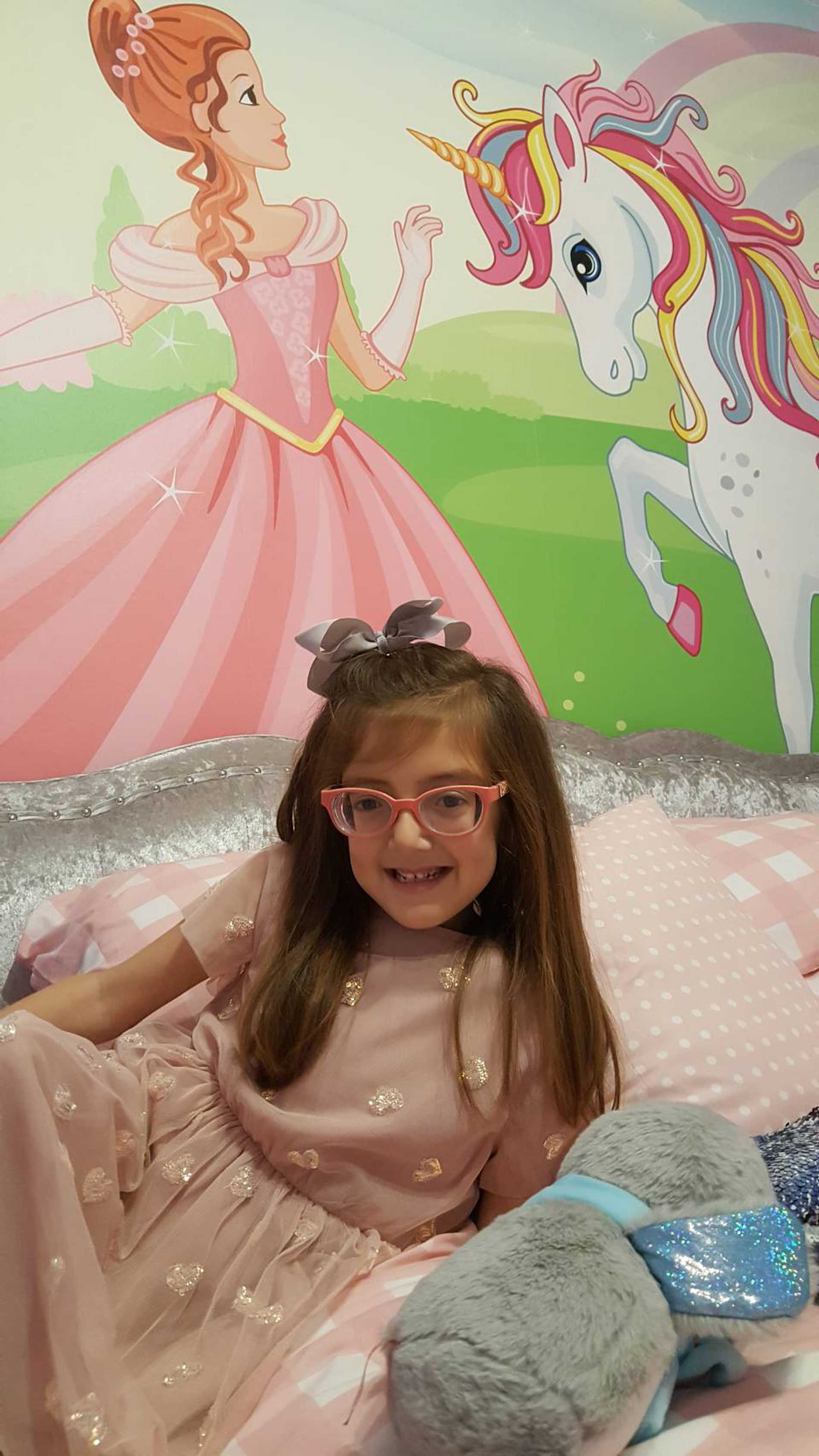 Smiling wish child, Tiara in her princess-themed bedroom.