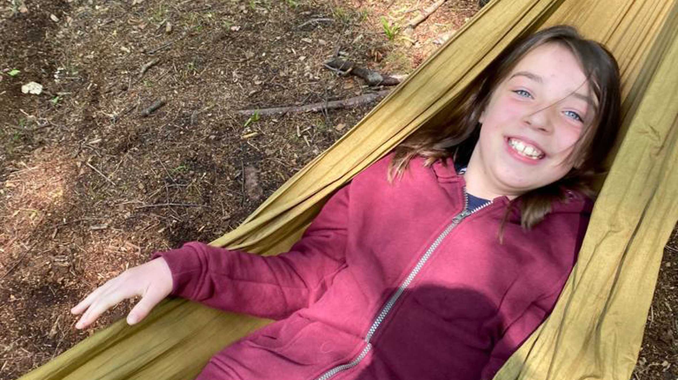 Emily laying in a hammock with a big smile on her face.