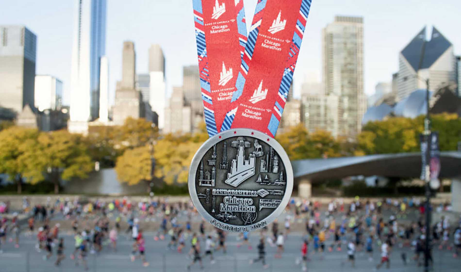 A close up of a Chicago Marathon finisher's medal, with the cityscape in the background.