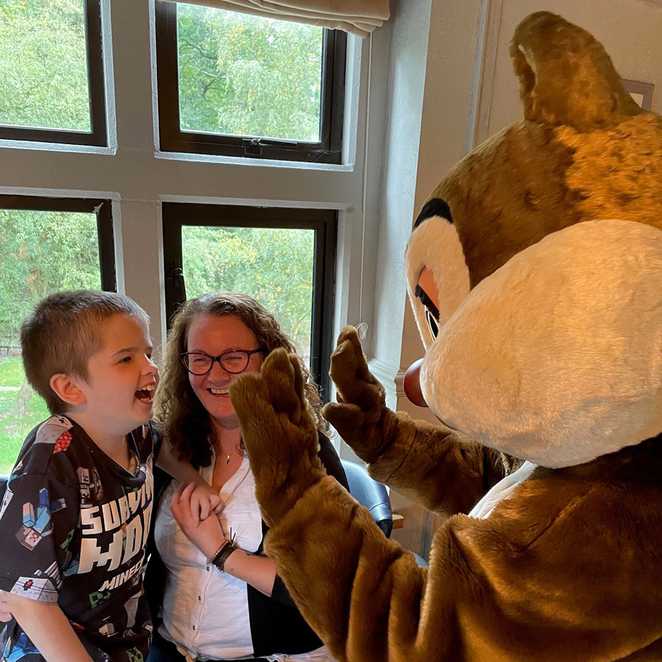 Lewis looking super excited to meet one of the characters from Chip and Dale, as mum holds him.