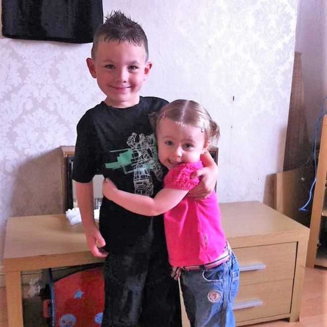 Amber holding her brother, Sheyne, before they were both diagnosed with Batten disease.