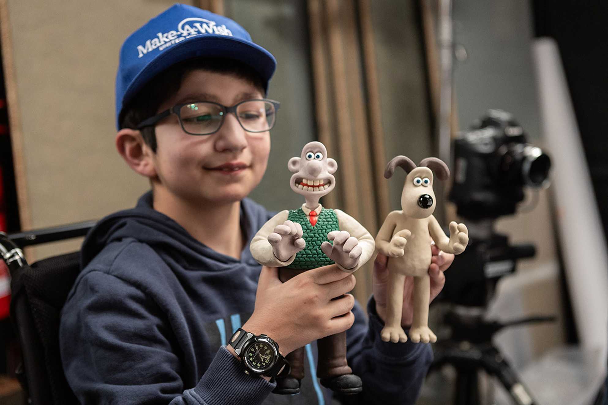 Mert (slightly out of focus), holds up some clay Wallace and Gromit figures