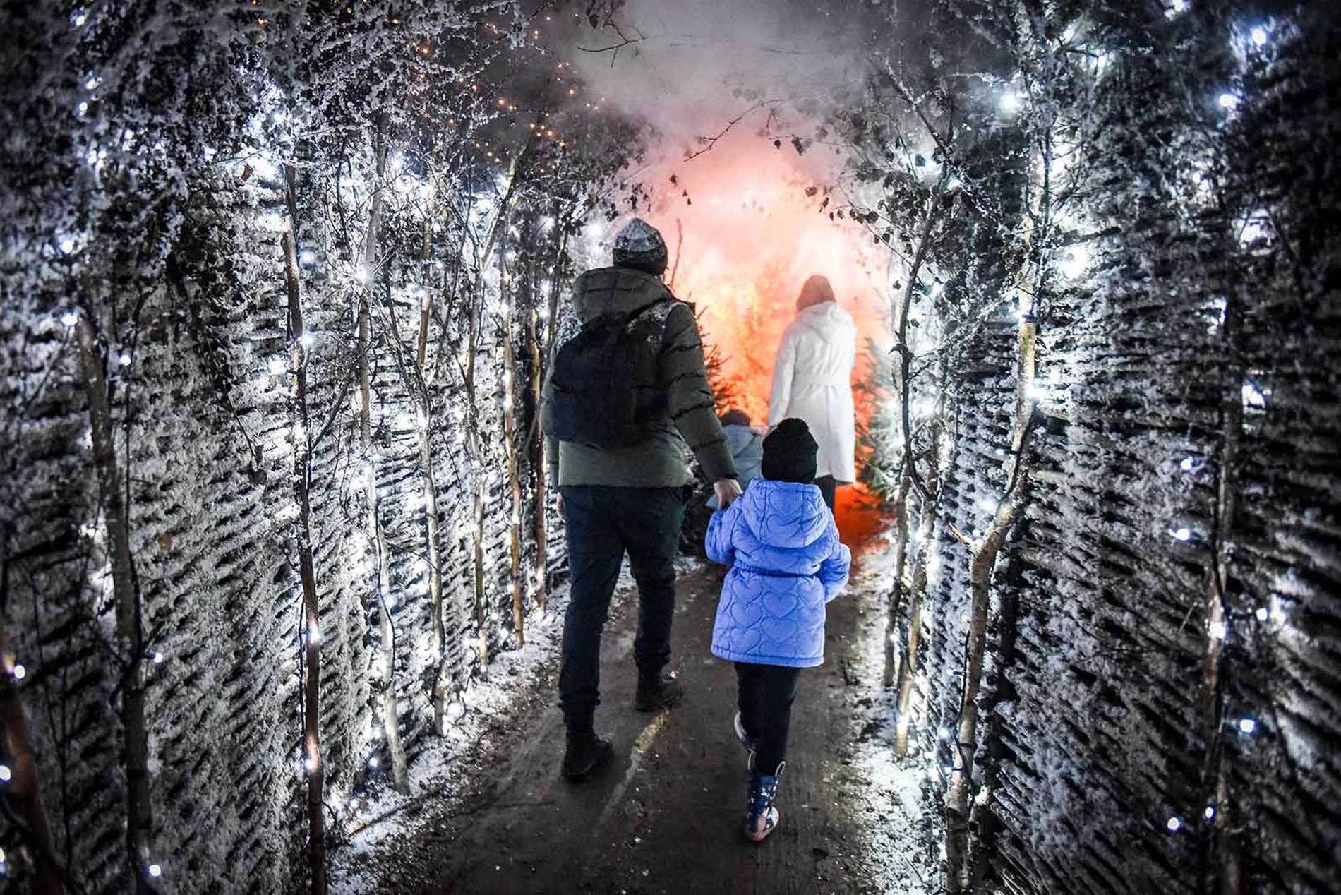 Julia and her family walking down a wintery, snow dusted pathway towards an orange glow.