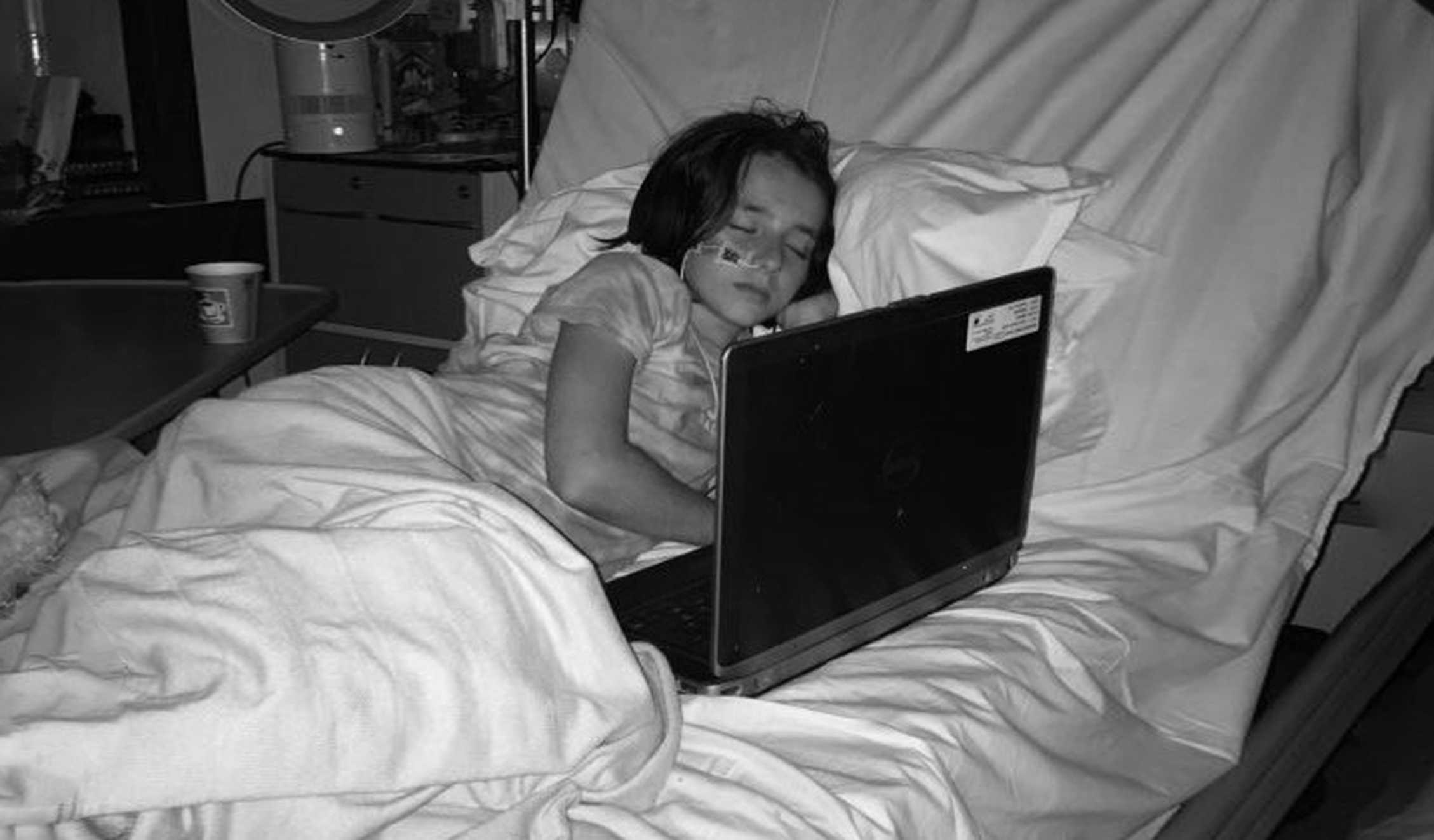 A black and white image of a younger Hattie, laying in her hospital bed during treatment for her condition.