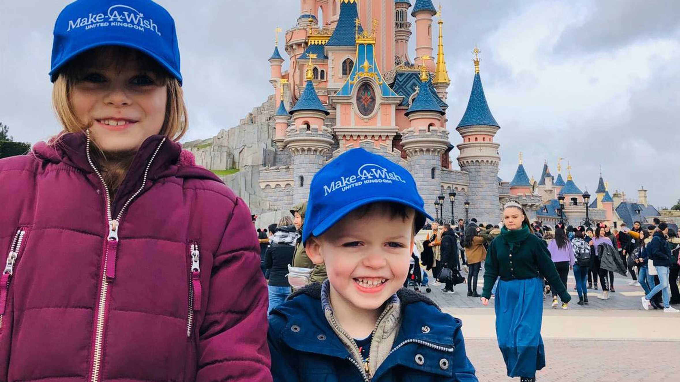 Ezekiel and his sister in front of the magical castle at Disneyland Paris.