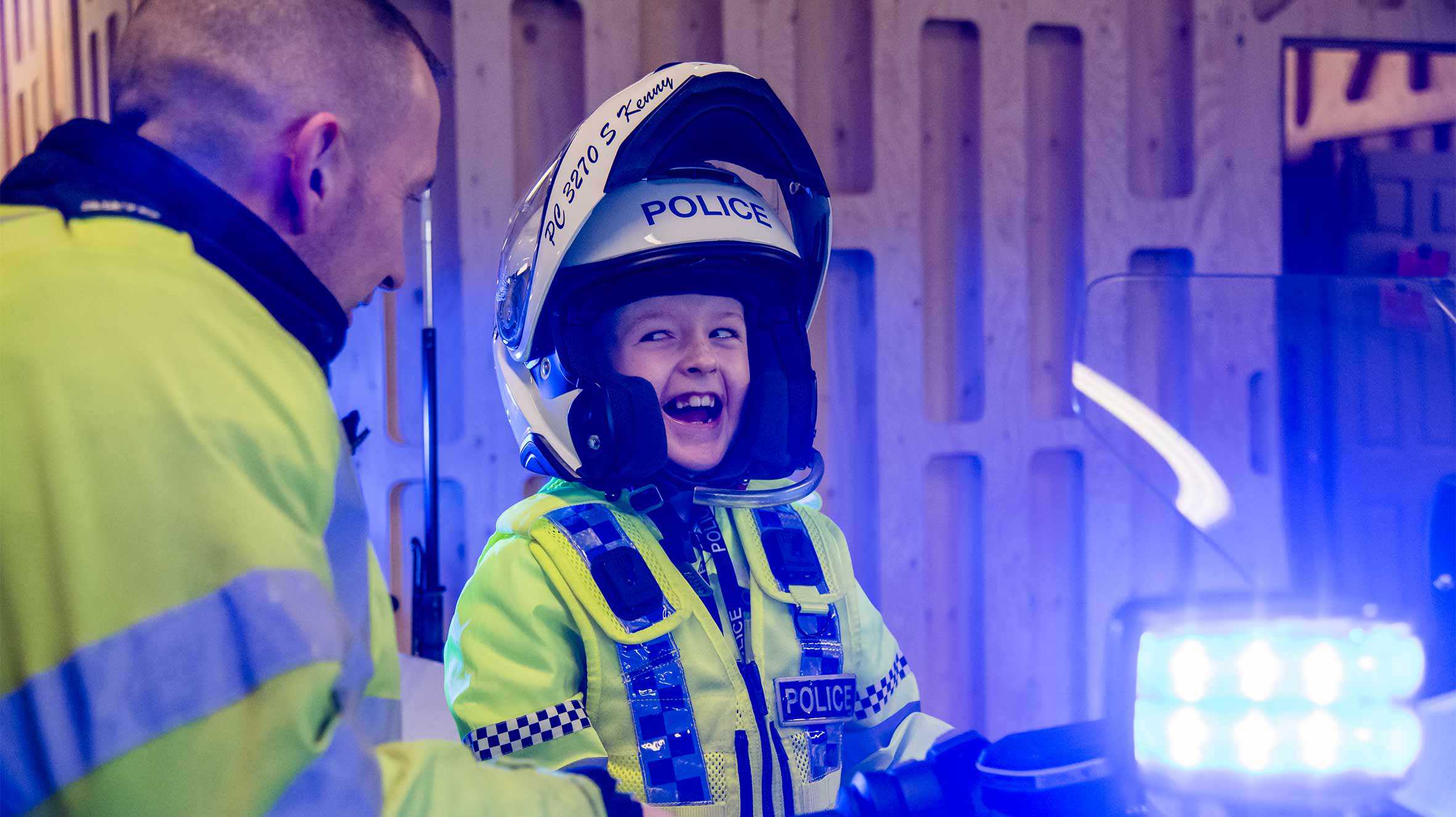 Allan joking with a colleague as he sits on a police motorbike