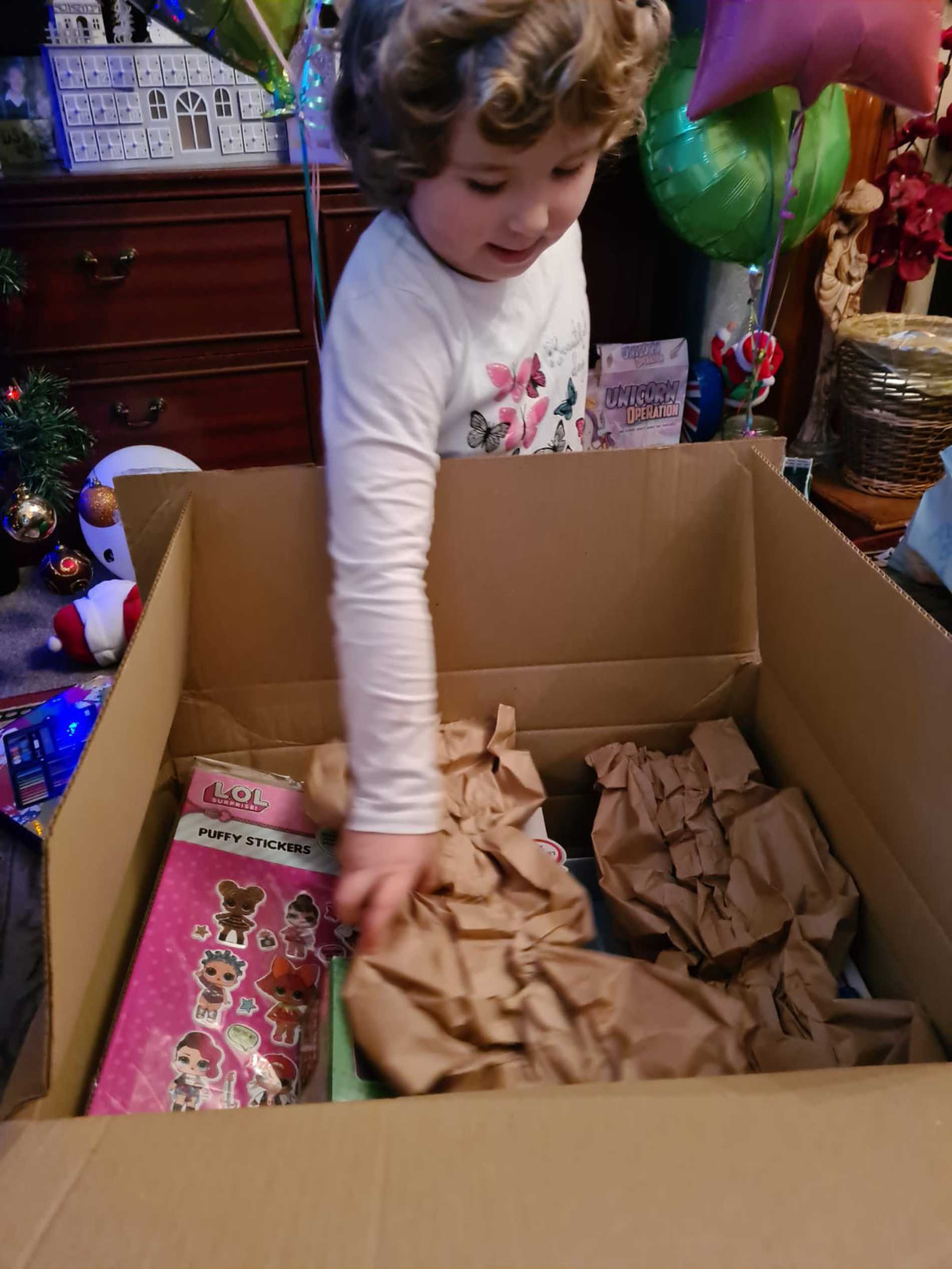 An excited Leah opening a big box of birthday presents. 